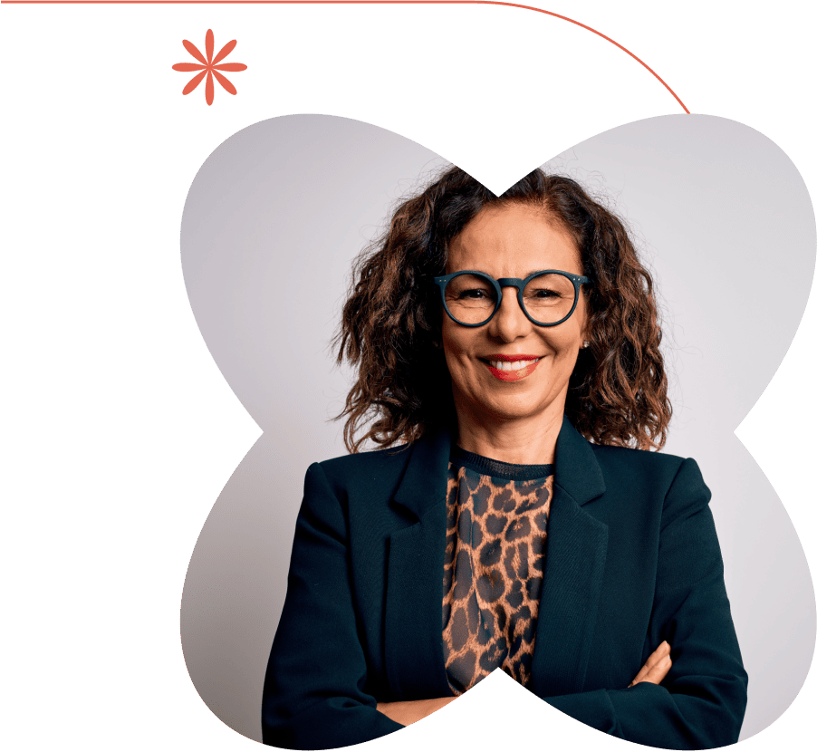 Confident woman with curly hair and glasses, smiling with arms crossed, framed by a floral graphic and wearing a dark blazer.