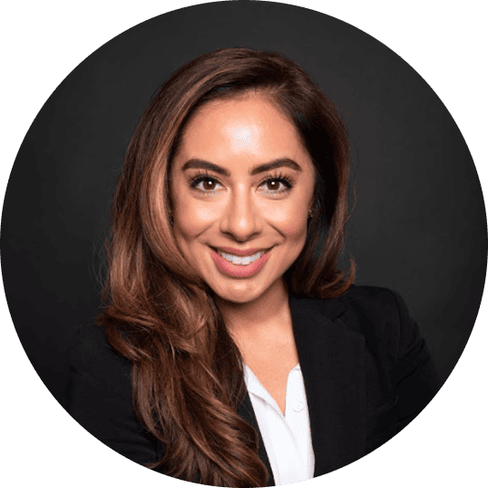 Portrait of speaker Dr. Lori Ochoa smiling at the camera, wearing a black suit and posing against a dark background.